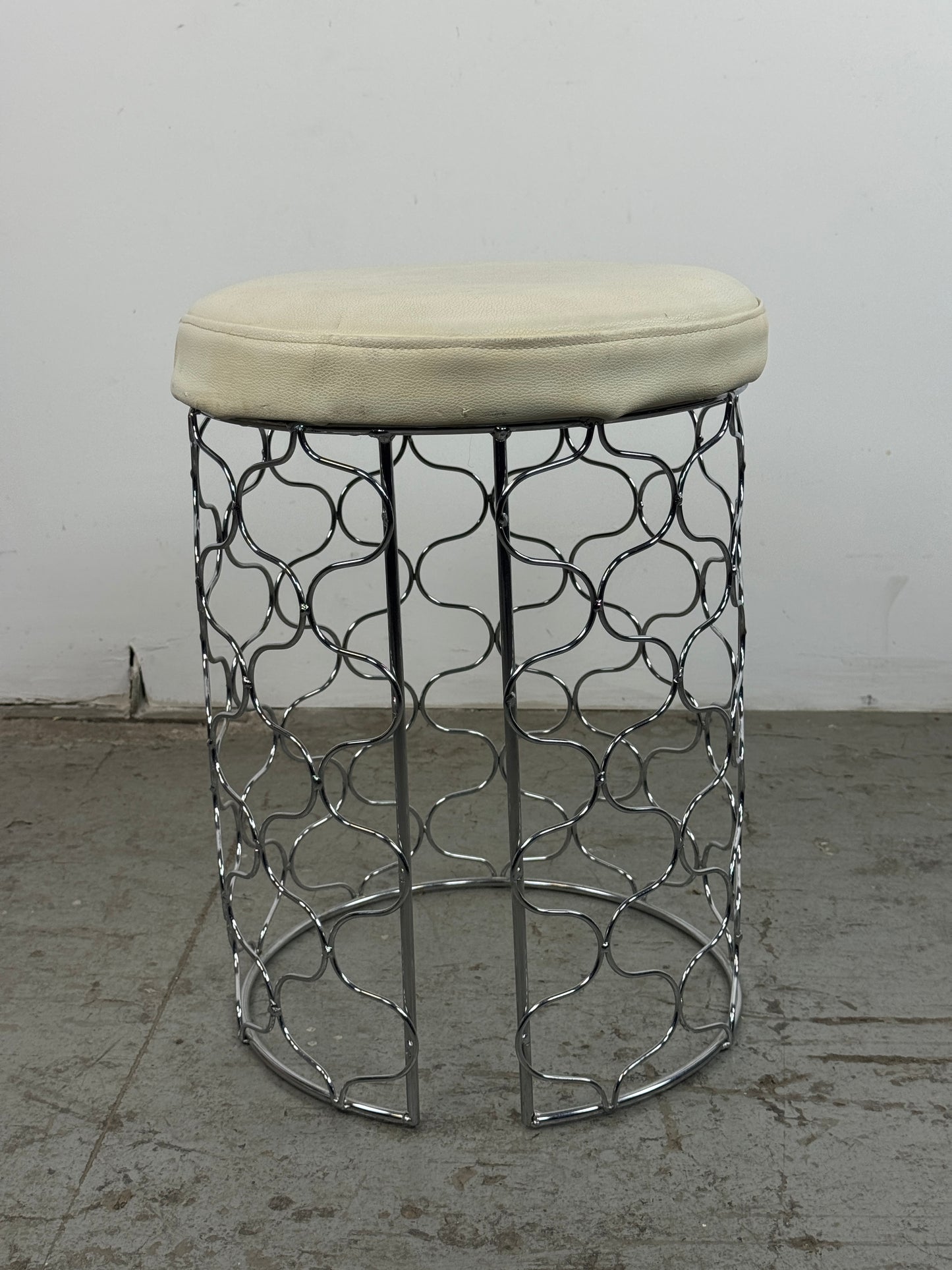 Taburete acolchado con base cromada y círculos