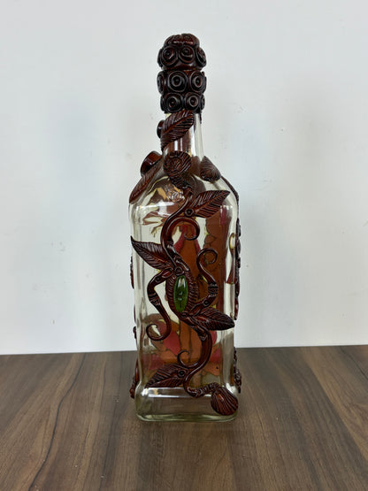 Botella de vidrio decorativa con tallados de resina