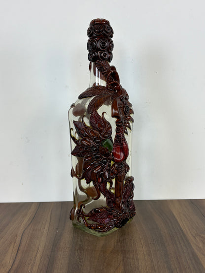 Botella de vidrio decorativa con tallados de resina