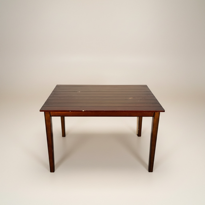 Mesa de comedor cuadrada con cubierta de madera en tono tabaco o café oscuro, la cubierta y las patas están con rayones y piquetes – Go Vintage